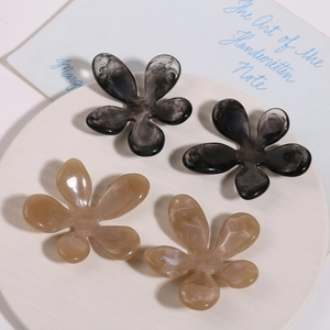 Detail of flower resin hair clips with ink marble patterns and translucent finish