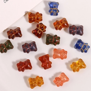 Macro view of transparent bear-shaped glass beads with gold outline for DIY jewelry making