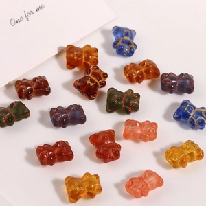 Macro shot of colorful glass bear beads for jewelry making with elegant gold accents