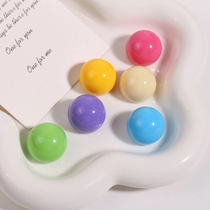 Macro shot of glossy Morandi resin round beads on a decorative white cloud tray for jewelry DIY