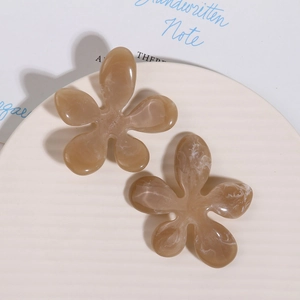 Detailed view of irregular marble pattern resin flower clips on a textured tray