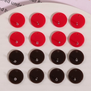 Macro shot of circular red and brown DIY earring bases with hanging holes for jewelry making
