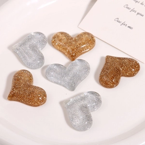 Close-up of sparkling gold and silver heart-shaped resin DIY craft accessory charms
