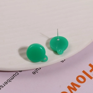 Close-up of green resin round earrings with hanging loops and silver needles