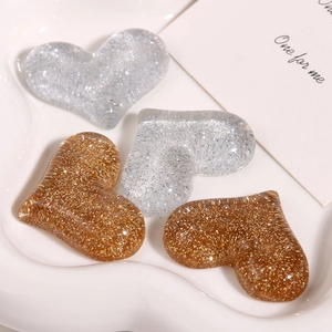 Detail of sequined heart-shaped resin charms in gold and silver for DIY accessories