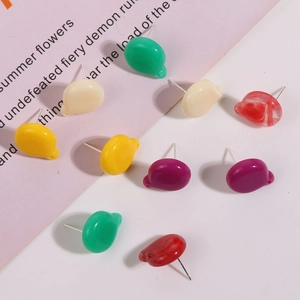 Macro detail of colorful resin earring studs in green, yellow, and marbled red