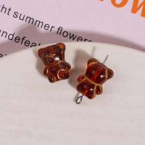 Macro detail of amber brown glass bear beads with gold outlines and metal pins