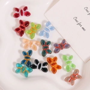 Close-up of colorful glass butterfly beads in various vibrant colors for DIY jewelry