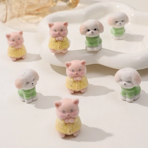 Dettaglio di simpatiche statuine floccate di maialini e cuccioli per gioielli fai-da-te