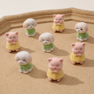 Dettaglio di 8 mini statuette di cuccioli e maialini floccati con maglioni colorati per fai da te