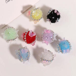 Detail von bunten DIY-Perlenkugeln mit glitzernden Strasssteinen und Schmetterlingsakzenten