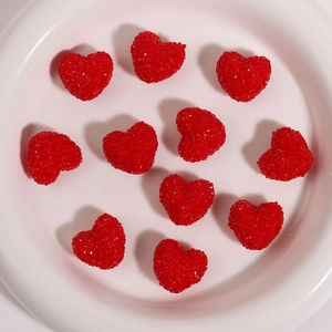 Macro detail of red 3D heart-shaped resin beads with faceted crystalline sugar texture