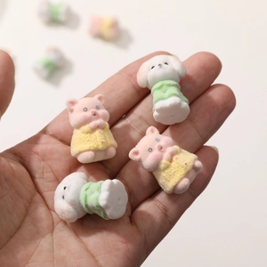 Dettaglio di mini figurine di cuccioli e maialini in resina floccata in colori pastello