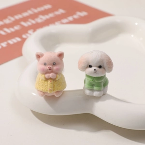 Primo piano di graziose statuette di maialino e cane floccate su un vassoio di ceramica