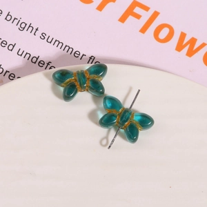 Macro view of blue Czech glass butterfly beads with gold trim for DIY jewelry making