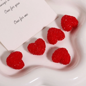 Close-up of 5 red 3D resin heart charms with sugar-ball texture on a white ceramic tray