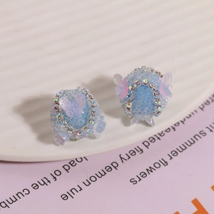 Detailansicht handgefertigter hellblauer Perlenohrringe mit lila Schmetterling und Strass