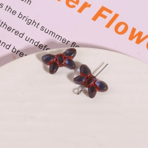 Macro shot of 3D glass butterfly earrings with translucent brown finish and metal posts