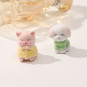 Dettaglio macro di figurine di cane e maiale floccate con trame di maglioni a maglia