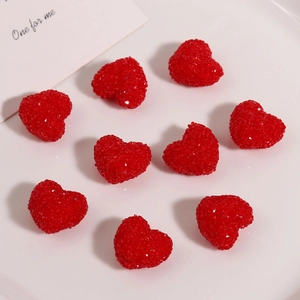 Macro detail of red resin heart charms with sparkling sugar bead texture for DIY crafts