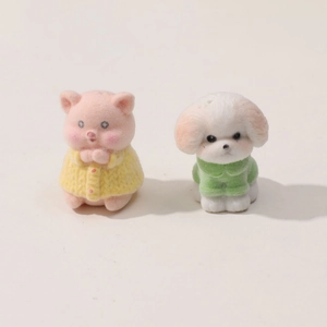 Dettaglio di figurine floccate di maialino e cucciolo con finiture in maglia testurizzata