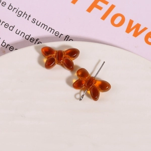 Macro view of amber translucent glass bow charms for DIY earring and jewelry making