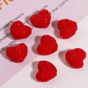 Macro detail of red resin heart charms with sparkling diamond-cut texture for DIY crafts