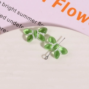 Detailed macro shot of translucent green glass butterfly pendant for DIY jewelry making
