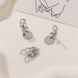Macro shot of silver-tone metal clip-on earring converters with round DIY base plates