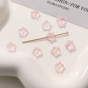 Vista macro de cuentas de vidrio estrella rosa 8mm con pin en T dorado para joyería DIY