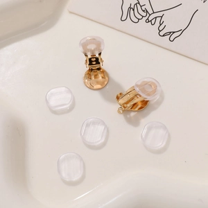 Detailed view of golden screw-on earring converters with clear silicone comfort pads