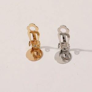 Detail view of gold and silver DIY spring ear clips with round flat trays for jewelry making