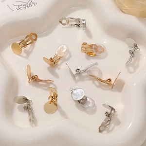 DIY gold and silver clip-on earring converters with pads on a star-shaped ceramic tray