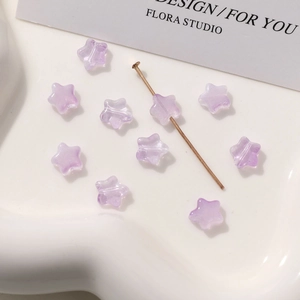 Detalle macro de cuentas de vidrio violetas de 8 mm en forma de estrella para joyería DIY