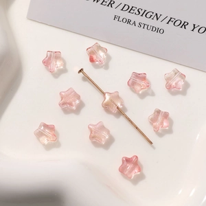Detalle macro de cuentas de vidrio rosa translúcido en forma de estrella con purpurina