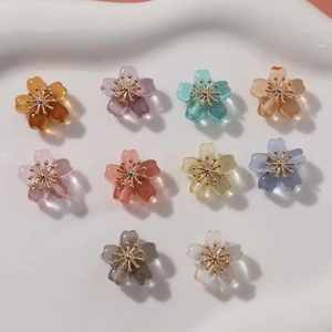 Close-up of colorful resin flower beads with gold metal centers for DIY jewelry
