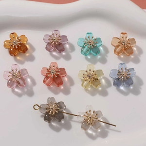 Colorful floral beads for jewelry making with gold stamens on a white ceramic tray