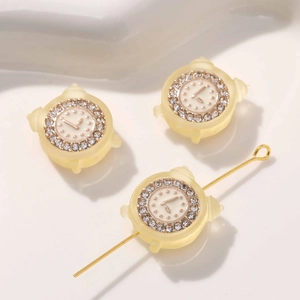 Makroaufnahme von gelben Wecker-Perlen mit Mini-Strass und Loch für DIY-Schmuck