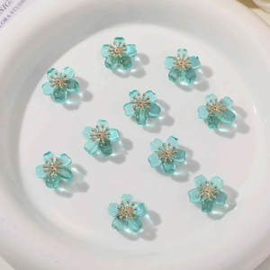 Macro view of blue translucent flower beads with gold centers for DIY jewelry making