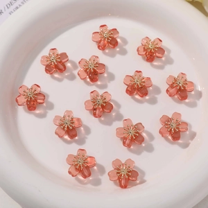 Macro shot of clear pink resin flower beads with golden stamens for DIY jewelry making