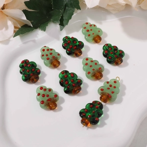 Detailed view of handmade green glass Christmas tree beads for DIY jewelry crafting