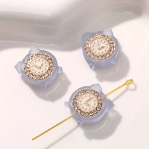 Makro-Detail von mattierten Mini-Wecker-Anhängern mit Strasssteinen für DIY-Schmuck