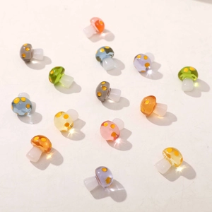 Close-up of colorful translucent resin mushroom charms with yellow polka dots for DIY jewelry
