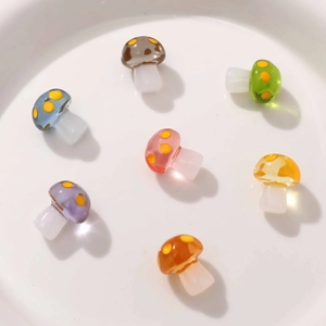 Macro view of colorful resin mushroom charms for DIY jewelry making in a white ceramic bowl