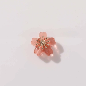 Detailed view of pink translucent five-petal flower bead with gold stamen for jewelry