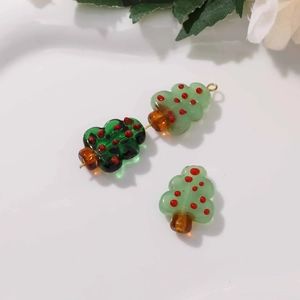 Macro detail of handmade Christmas tree glass beads with festive red dot patterns