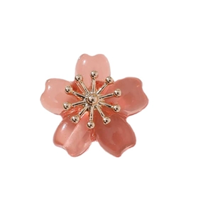 Pink translucent resin cherry blossom pendant with golden metal core on white background