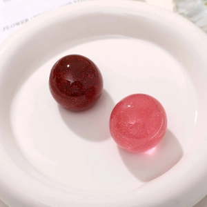 Macro view of glittering red and pink resin cherry fruit beads for DIY jewelry making