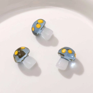 Close-up of translucent blue mushroom resin pendants with yellow dots for DIY jewelry