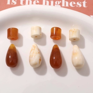 Vintage amber resin beads in cylindrical and teardrop shapes with marble texture